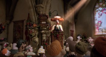 Movie still from “Wallace & Gromit: The Curse of the Were-Rabbit” (2005), directed by Nick Park – A group of people gathered around a podium with a clown on it; Wide shot, Low angle