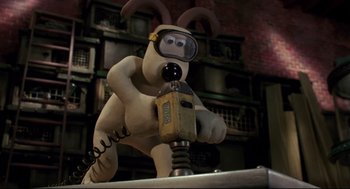 Movie still from “Wallace & Gromit: The Curse of the Were-Rabbit” (2005), directed by Nick Park – A statue of wallace and gromit holding a cell phone; Medium shot, Low angle