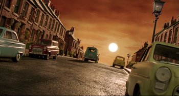 Movie still from “Wallace & Gromit: The Curse of the Were-Rabbit” (2005), directed by Nick Park – A street scene with cars parked on the side of the road; Wide shot, High angle