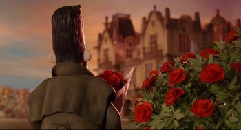 Movie still from “Wallace & Gromit: The Curse of the Were-Rabbit” (2005), directed by Nick Park – A statue of a man holding a bouquet of roses; Medium shot, Over the shoulder angle
