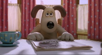 Movie still from “Wallace & Gromit: The Curse of the Were-Rabbit” (2005), directed by Nick Park – A dog sitting on top of a table next to a newspaper; Close Up shot, Over the shoulder angle