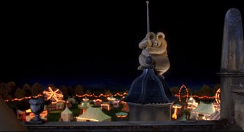 Movie still from “Wallace & Gromit: The Curse of the Were-Rabbit” (2005), directed by Nick Park – Two teddy bears on top of a pole in front of lights; Wide shot, Low angle