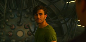 Movie still from “Another Life” (2019), created by Aaron Martin – A man in a green t - shirt standing in front of a wall; Close Up shot, Low angle