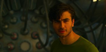 Movie still from “Another Life” (2019), created by Aaron Martin – A person wearing a green shirt; Close Up shot, Over the shoulder angle