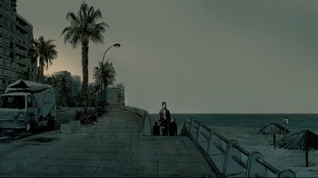 Movie still from “Waltz with Bashir” (2008), directed by Ari Folman – A man sitting on a bench next to the ocean; Extreme Wide shot, High angle