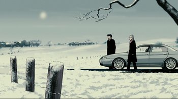 Movie still from “Waltz with Bashir” (2008), directed by Ari Folman – Two people walking in the snow next to a silver car; Wide shot, Low angle