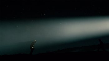 Movie still from “Waltz with Bashir” (2008), directed by Ari Folman – A man standing in the dark under a cloudy sky at night; Extreme Wide shot, Low angle