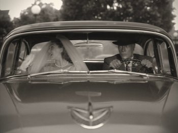 Movie still from “WandaVision” (2021), directed by Matt Shakman – A man and a woman sitting in the back seat of a car; Close Up shot, High angle