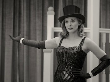 Movie still from “WandaVision” (2021), directed by Matt Shakman – A woman wearing a top hat and gloves; Medium shot, Low angle