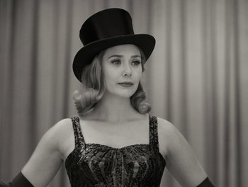 Movie still from “WandaVision” (2021), directed by Matt Shakman – A woman wearing a top hat and gloves; Close Up shot, Low angle