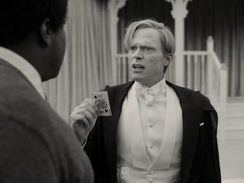 Movie still from “WandaVision” (2021), directed by Matt Shakman – A man in a tuxedo holding a card in his hand; Close Up shot, Over the shoulder angle