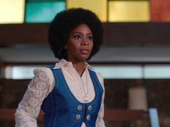 Movie still from “WandaVision” (2021), directed by Matt Shakman – A woman in a white shirt and a blue vest; Medium shot, Low angle