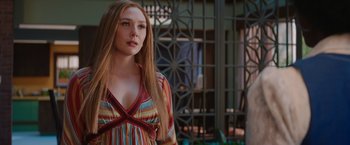 Movie still from “WandaVision” (2021), directed by Matt Shakman – A beautiful young lady wearing a colorful dress; Medium shot, Over the shoulder angle