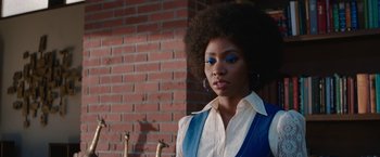 Movie still from “WandaVision” (2021), directed by Matt Shakman – A woman with blue eye shadow standing in front of a brick wall; Close Up shot, Over the shoulder angle