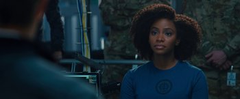 Movie still from “WandaVision” (2021), directed by Matt Shakman – A woman in a blue t - shirt is looking at the camera; Close Up shot, Over the shoulder angle