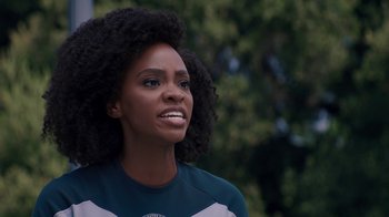 Movie still from “WandaVision” (2021), directed by Matt Shakman – A person wearing a shirt with trees in the background; Close Up shot, Over the shoulder angle