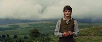 Movie still from “War Horse” (2011), directed by Steven Spielberg – A young man holding an apple in a field; Medium shot, Low angle
