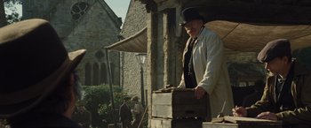 Movie still from “War Horse” (2011), directed by Steven Spielberg – An older man in a top hat is holding a suitcase; Wide shot, Low angle