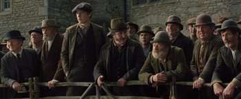 Movie still from “War Horse” (2011), directed by Steven Spielberg – A group of men standing next to each other on top of a fence; Medium shot, Low angle