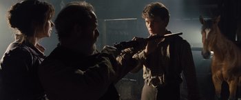 Movie still from “War Horse” (2011), directed by Steven Spielberg – A man and a young boy are in the dark; Medium shot, Over the shoulder angle