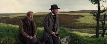 Movie still from “War Horse” (2011), directed by Steven Spielberg – Two men sitting next to each other on top of a hill; Medium shot, Over the shoulder angle