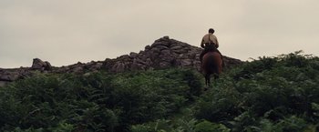 Movie still from “War Horse” (2011), directed by Steven Spielberg – A man riding a horse up a hill; Extreme Wide shot, Low angle