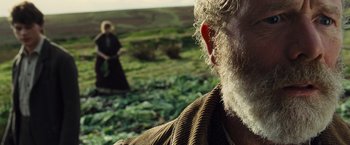 Movie still from “War Horse” (2011), directed by Steven Spielberg – An old man with a beard and a woman in a field; Close Up shot, Over the shoulder angle