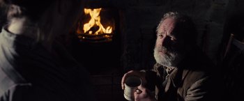 Movie still from “War Horse” (2011), directed by Steven Spielberg – An older man holding a mug in front of a fireplace; Close Up shot, Over the shoulder angle