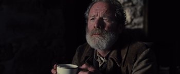Movie still from “War Horse” (2011), directed by Steven Spielberg – An older man holding a coffee mug in a dark room; Close Up shot, Low angle