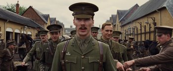 Movie still from “War Horse” (2011), directed by Steven Spielberg – A group of men in uniform walking down a street; Medium shot, Over the shoulder angle