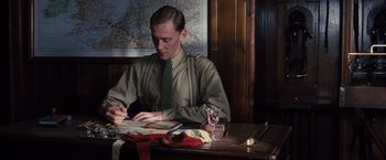 Movie still from “War Horse” (2011), directed by Steven Spielberg – A man sitting at a table writing on a piece of paper; Medium shot, High angle