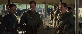 Movie still from “War Horse” (2011), directed by Steven Spielberg – A group of men in military uniforms standing in front of a tent; Medium shot, Over the shoulder angle