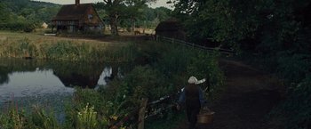 Movie still from “War Horse” (2011), directed by Steven Spielberg – An old woman walking down a path near a pond; Extreme Wide shot, High angle