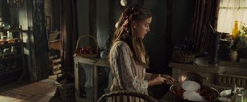 Movie still from “War Horse” (2011), directed by Steven Spielberg – A young girl wearing a dress and holding a knife; Medium shot, Over the shoulder angle