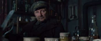 Movie still from “War Horse” (2011), directed by Steven Spielberg – A man in a military uniform sitting in front of a table; Close Up shot, Low angle