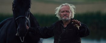 Movie still from “War Horse” (2011), directed by Steven Spielberg – An older man with long white hair and a beard; Medium shot, Low angle