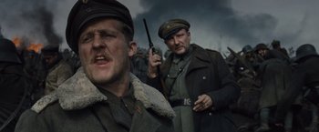 Movie still from “War Horse” (2011), directed by Steven Spielberg – A group of men standing next to each other in a field; Close Up shot, Low angle