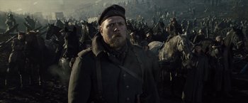 Movie still from “War Horse” (2011), directed by Steven Spielberg – A man with a beard and a hat in a crowd of people; Medium shot, Low angle