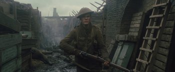 Movie still from “War Horse” (2011), directed by Steven Spielberg – A man holding a rifle while standing in a field; Medium shot, Low angle