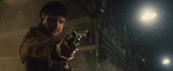 Movie still from “War Horse” (2011), directed by Steven Spielberg – A man holding a gun while standing next to a building; Close Up shot, Low angle