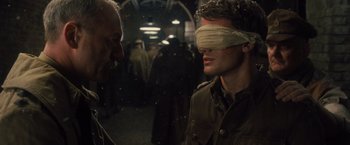 Movie still from “War Horse” (2011), directed by Steven Spielberg – A man with a blindfold on his head talking to another man; Close Up shot, Over the shoulder angle