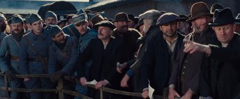 Movie still from “War Horse” (2011), directed by Steven Spielberg – A group of men standing next to each other on a field; Medium shot, Low angle