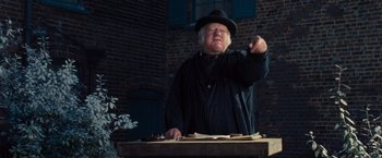 Movie still from “War Horse” (2011), directed by Steven Spielberg – An old man wearing a black hat and a black coat; Medium shot, Low angle