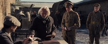 Movie still from “War Horse” (2011), directed by Steven Spielberg – A man in a military uniform standing next to another man in a military uniform; Medium shot, Over the shoulder angle