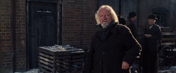 Movie still from “War Horse” (2011), directed by Steven Spielberg – An old man with a beard and a black jacket; Medium shot, Over the shoulder angle