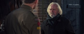 Movie still from “War Horse” (2011), directed by Steven Spielberg – A man in a military uniform talking to another man in a black jacket; Medium shot, Over the shoulder angle