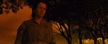 Movie still from “War Horse” (2011), directed by Steven Spielberg – A woman standing in front of a tree at night; Medium shot, Low angle