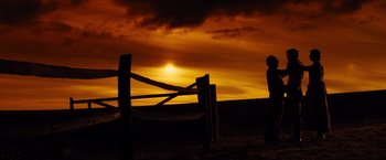 Movie still from “War Horse” (2011), directed by Steven Spielberg – A person standing in front of a fence at sunset; Extreme Wide shot, Low angle
