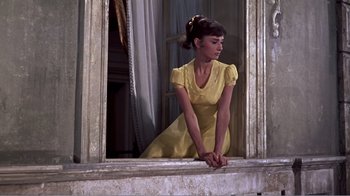 Movie still from “War and Peace” (1956), directed by King Vidor – A woman in a yellow dress sitting on a window sill; Medium shot, Low angle