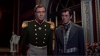 Movie still from “War and Peace” (1956), directed by King Vidor – A man in a uniform standing next to another man in a suit; Medium shot, Low angle
